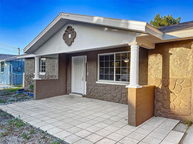 view of exterior entry featuring a patio