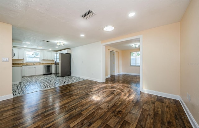 unfurnished living room with tile flooring and sink