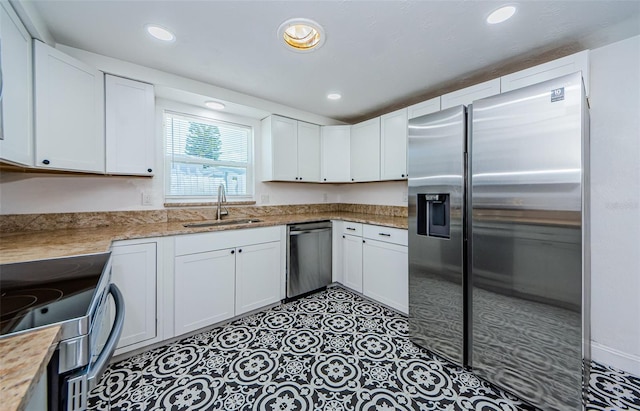 kitchen with white cabinetry, appliances with stainless steel finishes, sink, and light tile floors