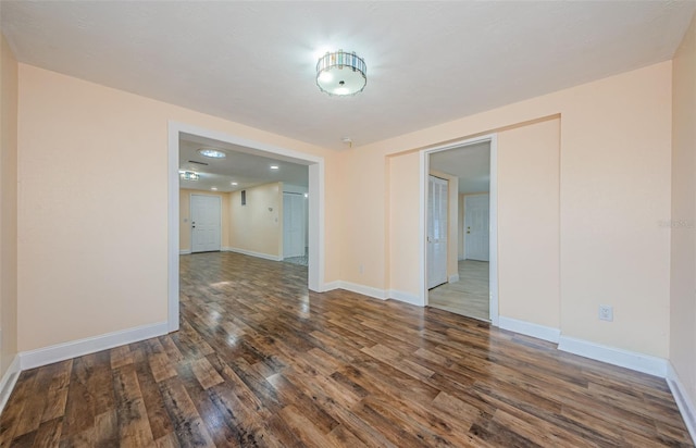 unfurnished room with dark wood-type flooring