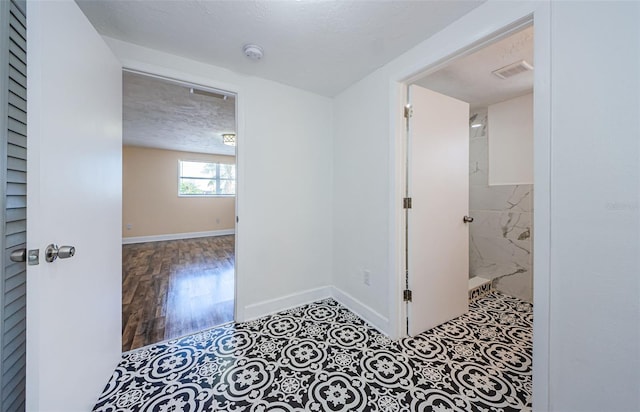 corridor with tile flooring and a textured ceiling