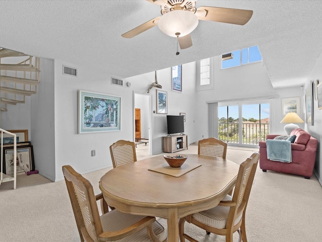 dining area featuring stairway, light colored carpet, visible vents, and a textured ceiling