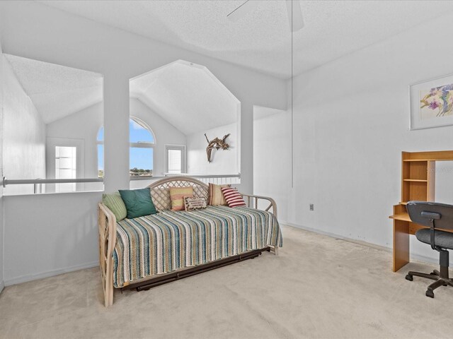 bedroom with ceiling fan, a textured ceiling, carpet, and vaulted ceiling