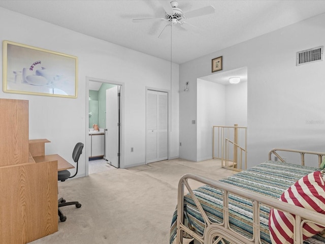 bedroom featuring visible vents, a ceiling fan, light carpet, connected bathroom, and a textured ceiling