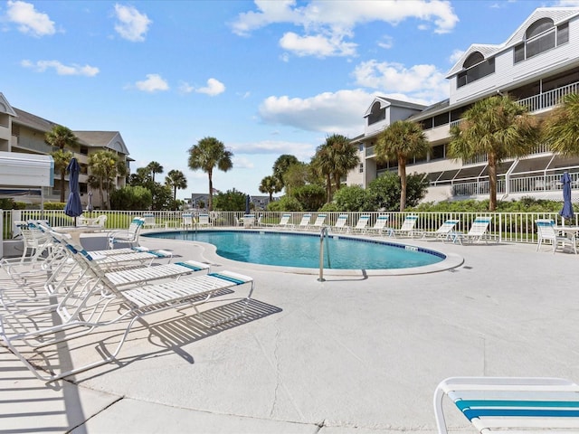 community pool featuring a patio area and fence