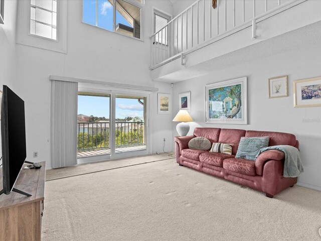 carpeted living room featuring a high ceiling