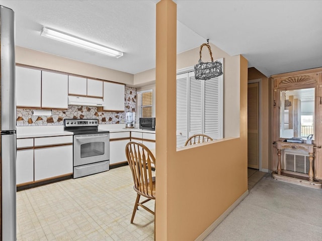 kitchen featuring white cabinets, light floors, stainless steel appliances, light countertops, and under cabinet range hood