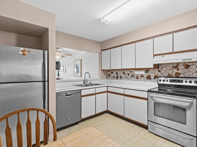 kitchen featuring under cabinet range hood, stainless steel appliances, a sink, white cabinetry, and light countertops