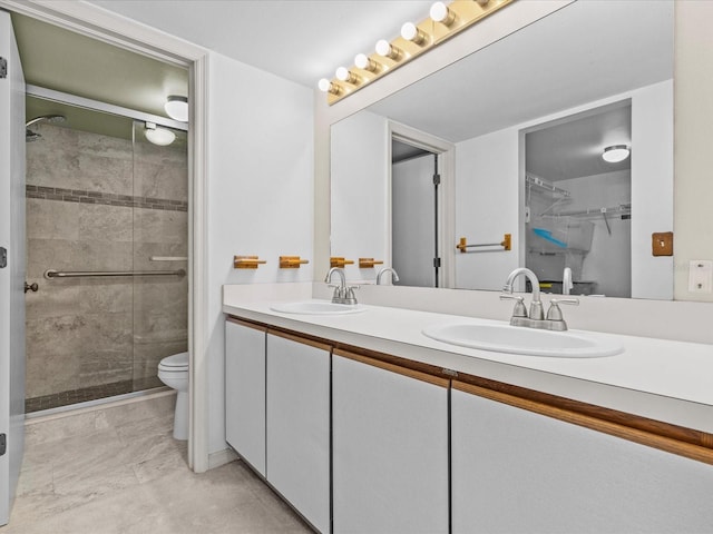 bathroom featuring double vanity, a sink, and a shower stall