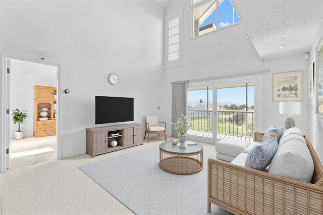 carpeted living room featuring a textured ceiling and a towering ceiling