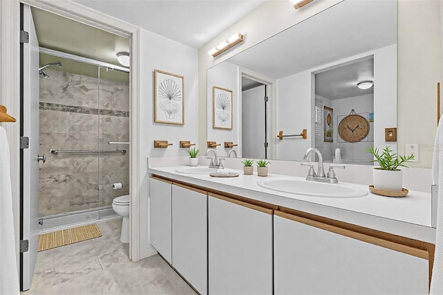 bathroom featuring a stall shower, a sink, toilet, and double vanity