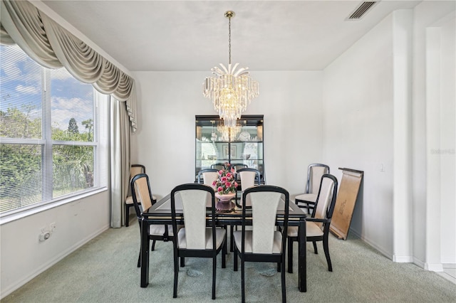 carpeted dining room with a notable chandelier