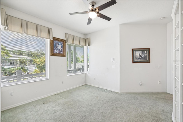 spare room with ceiling fan and light colored carpet