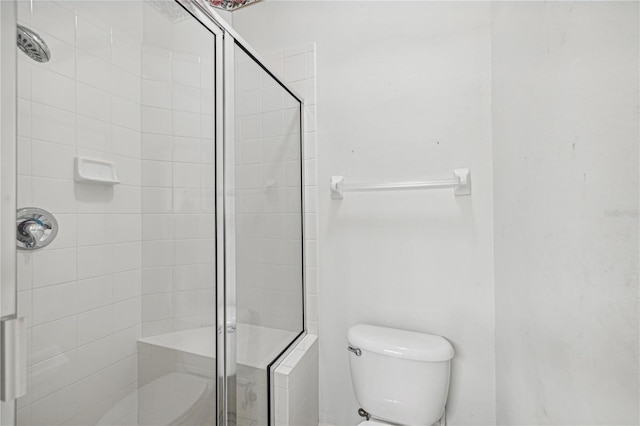 bathroom with toilet and a shower with door