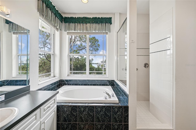 bathroom featuring vanity, plus walk in shower, and a healthy amount of sunlight