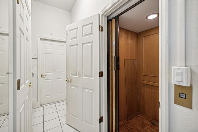 corridor with light tile patterned floors and elevator