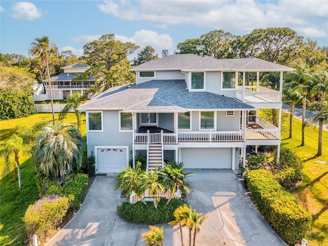 coastal home featuring a porch, a garage, and a balcony