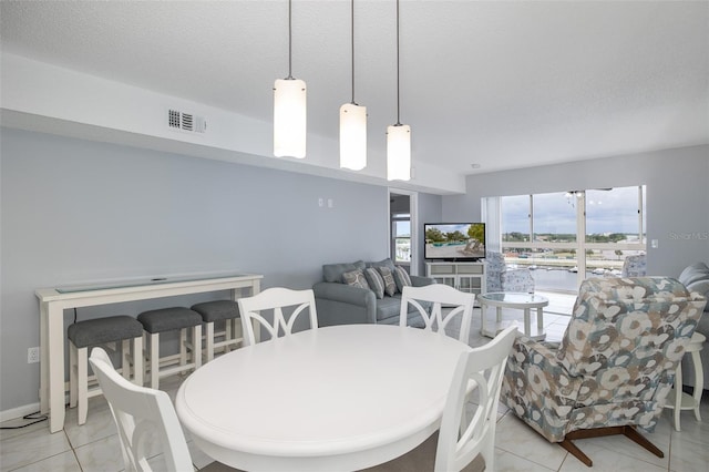 tiled dining area with a textured ceiling