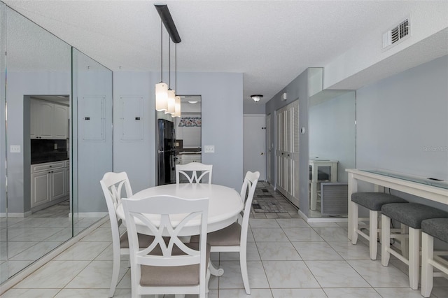 tiled dining area featuring electric panel and a textured ceiling