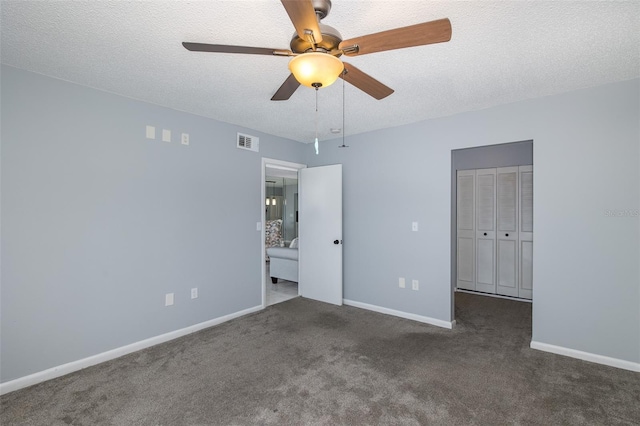 unfurnished bedroom with ceiling fan, a textured ceiling, and dark colored carpet