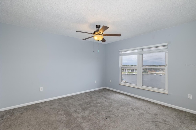 carpeted spare room featuring ceiling fan and a textured ceiling