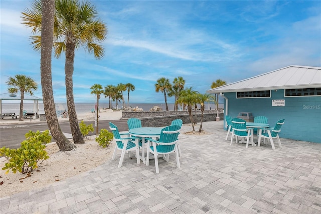 view of patio / terrace featuring a view of the beach and a water view