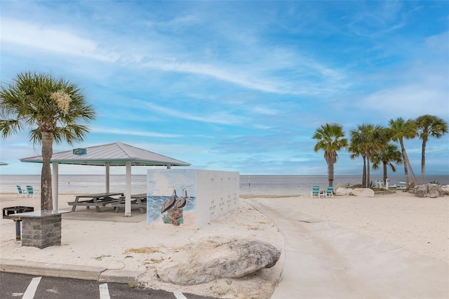 surrounding community featuring a water view, a beach view, and a gazebo