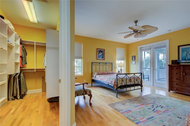 bedroom featuring ceiling fan, access to exterior, a closet, and light wood-type flooring