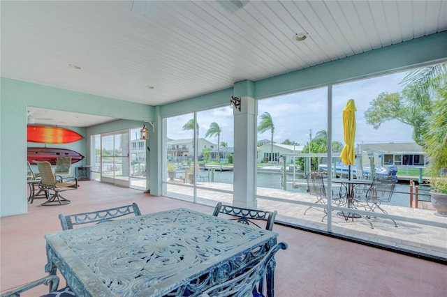 sunroom / solarium featuring a water view