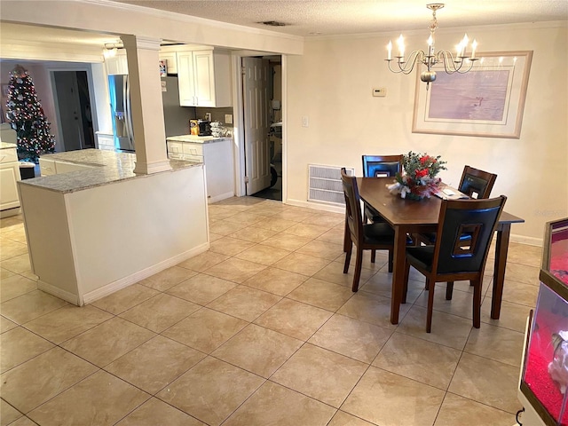 tiled dining room featuring a chandelier and a textured ceiling