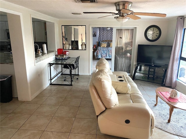 tiled living room with ceiling fan and a textured ceiling