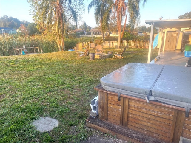 view of yard featuring a hot tub and an outdoor fire pit