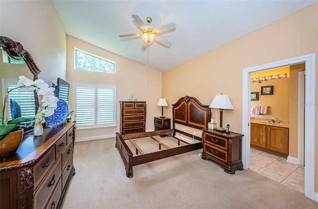 bedroom featuring ensuite bath, ceiling fan, light colored carpet, and vaulted ceiling