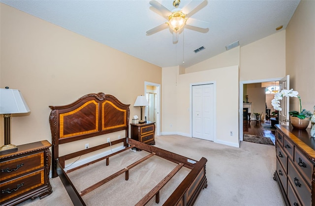 carpeted bedroom with ceiling fan, vaulted ceiling, and a closet