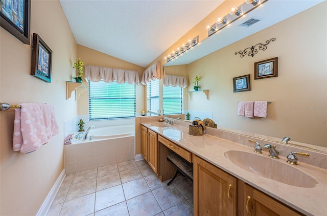 bathroom featuring a textured ceiling, vanity, tile patterned flooring, tiled bath, and lofted ceiling