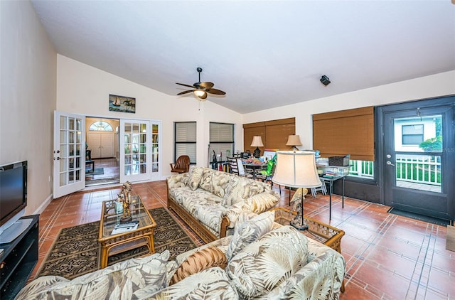 tiled living room with ceiling fan, lofted ceiling, and french doors