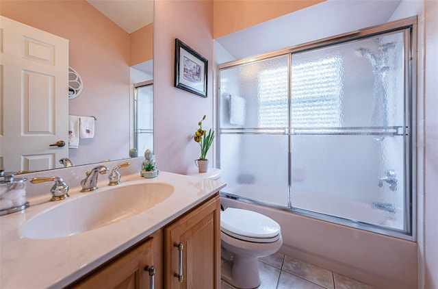 full bathroom featuring toilet, a wealth of natural light, tile patterned flooring, and combined bath / shower with glass door