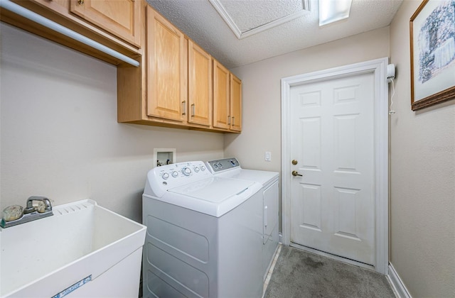 laundry room with cabinets, a textured ceiling, sink, washing machine and clothes dryer, and carpet floors