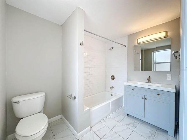 bathroom with vanity, toilet, marble finish floor, baseboards, and  shower combination