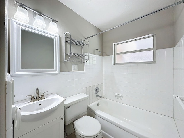 bathroom with vanity, shower / bathing tub combination, toilet, and tile walls
