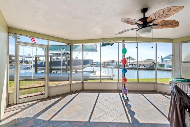 sunroom / solarium with a water view and ceiling fan