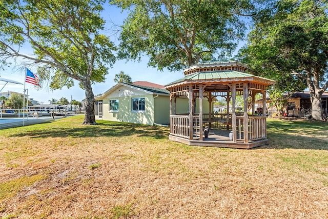 back of property featuring a gazebo and a lawn