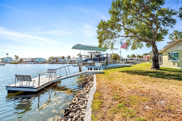 view of dock with a water view and a lawn