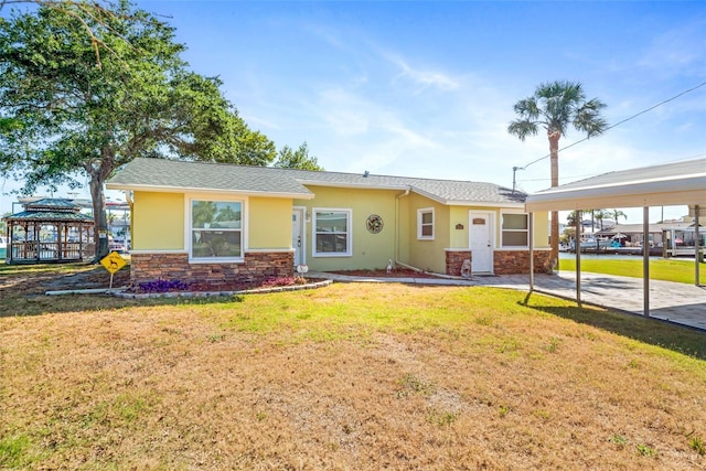 ranch-style house featuring a carport and a front lawn