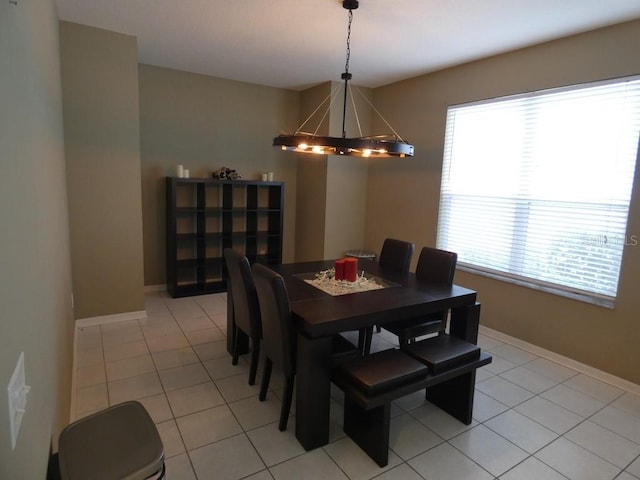 tiled dining room featuring a chandelier