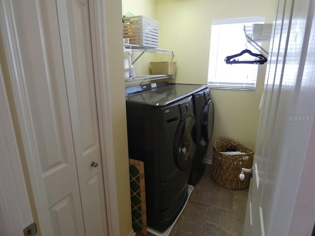 clothes washing area featuring washer and clothes dryer and tile patterned flooring