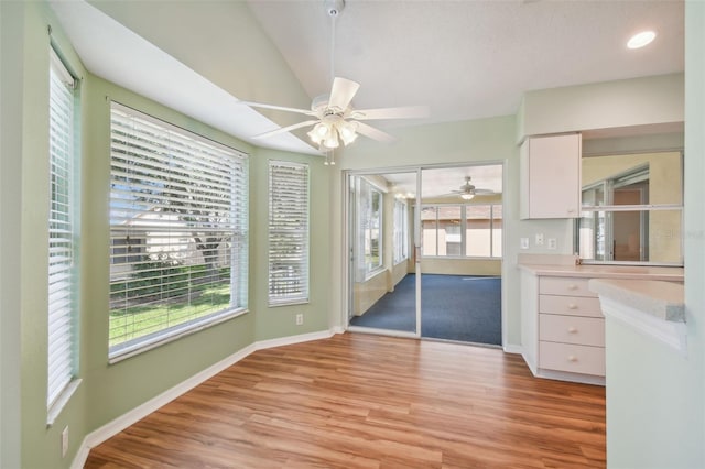 interior space featuring ceiling fan, light hardwood / wood-style flooring, white cabinets, and a healthy amount of sunlight