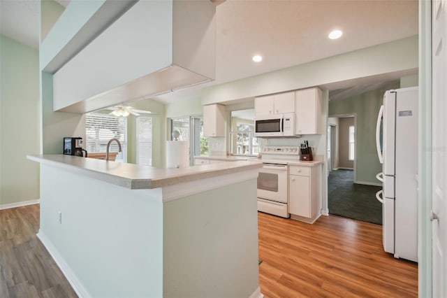 kitchen with light wood-type flooring, white appliances, white cabinetry, and ceiling fan