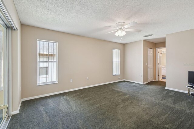 carpeted empty room featuring ceiling fan and a textured ceiling