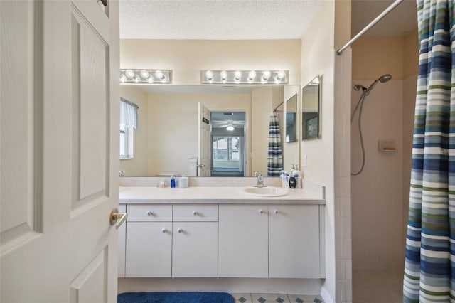 bathroom with a shower with curtain, ceiling fan, a textured ceiling, and vanity